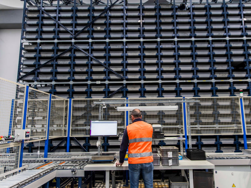 A picture showing a engineer operate an automated storage and retrieval system for reference