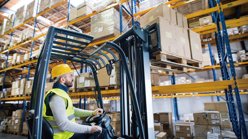 An Imange Showing A male forklift operator picking up the goods on pallet